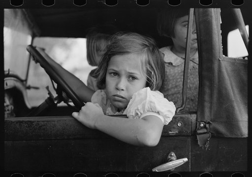 Child of farmer sitting in automobile waiting for father to come out of general store, Jarreau, Louisiana