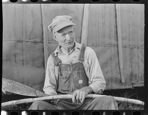 Day laborer with sugarcane knife in front of his shack home near New Iberia, Louisiana