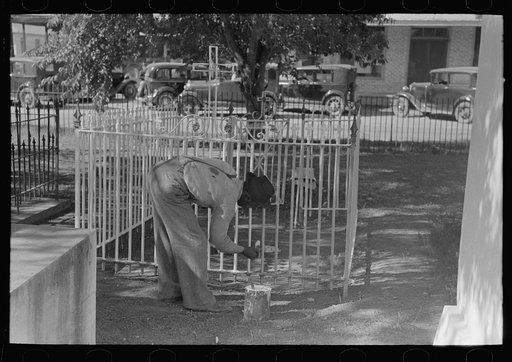 Untitled photo, possibly related to: Woman decorating family burial vaults in cemetery at New Roads, Louisiana on All Saints' Day