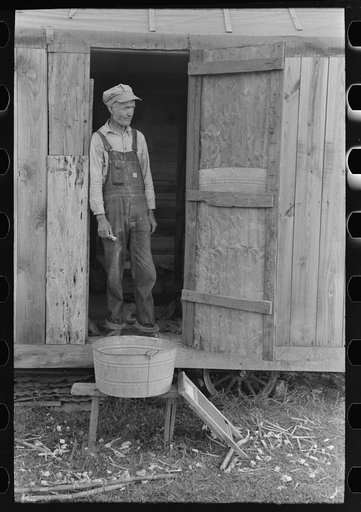 Day laborer standing in doorway of his home in sugarcane fields, near New Iberia, Louisiana