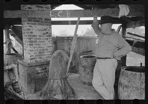Untitled photo, possibly related to: Owner atop his turpentine still. Goosneck runs from the still to the condenser coils where vapors are chilled. State Line, Mississippi