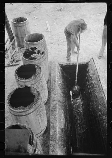 Scooping up the resin from settling vat. Resin is then poured into barrels for shipping. State Line, Mississippi
