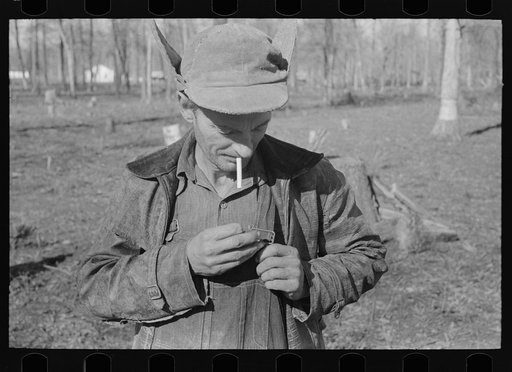 Untitled photo, possibly related to: Farmer of Chicot Farms, Arkansas striking match on button of overalls