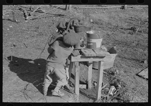 Children of Negro sharecropper pumping water. Family will be resettled at Transylvania Project, Louisiana