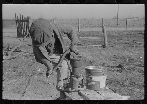 Untitled photo, possibly related to: Children of Negro sharecropper pumping water. Family will be resettled at Transylvania Project, Louisiana