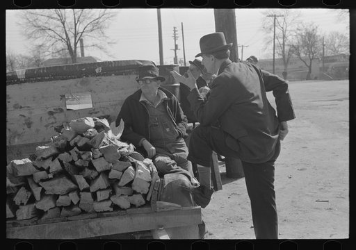Man talking to farmer with truckload of wood, Laurel, Mississippi
