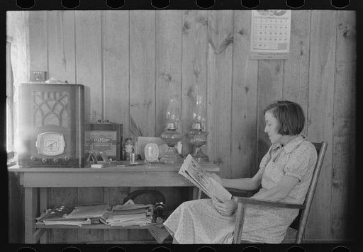 House wife reading in living room, Chicot Farms, Arkansas