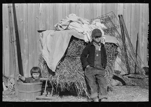 Children in front of household goods at side of house. These people came from a western parish and brought all their household goods for which they have no storage space in temporary housing provided at Transylvania Project, Louisiana