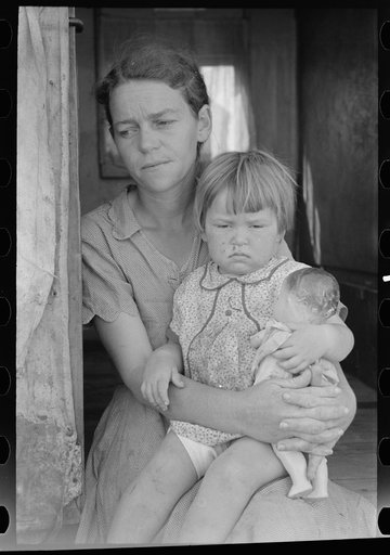 White migrant mother with daughter in door of trailer home near Weslaco, Texas