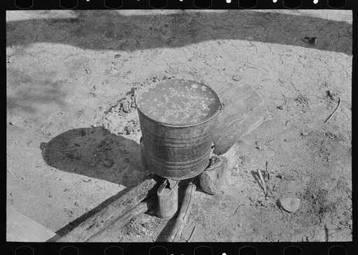 Cooking corn preparatory to making tortillas in front of Mexican hut, near Santa Maria, Texas