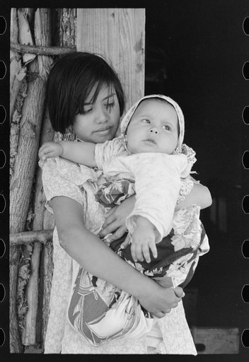 Mexican girl with baby sister in front of hut near Santa Maria, Texas