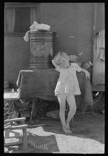 Untitled photo, possibly related to: Child of migrant family in front of household goods of trailer home, Weslaco, Texas