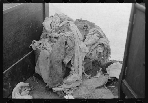 Pile of raggedy clothing in tent home of migrants near Harlingen, Texas