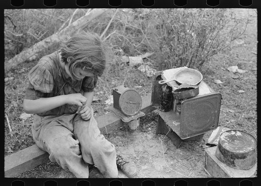 A child of white migrant in her playhouse. The rusted scales represented a clock to the little girl. Near Harlingen, Texas