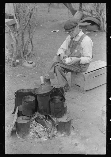 Untitled photo, possibly related to: White migrant worker sawing wood for stakes to be used in setting up tent home, near Harlingen, Texas