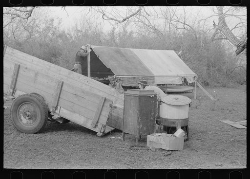 Untitled photo, possibly related to: Unloading household goods from trailer in process of setting up camp near Harlingen, Texas