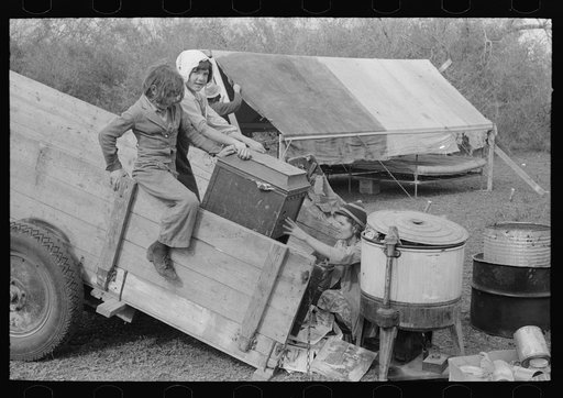 Unloading household goods from trailer in process of setting up camp near Harlingen, Texas