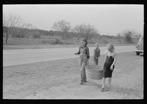 Untitled photo, possibly related to: Unloading household goods from trailer in process of setting up camp near Harlingen, Texas