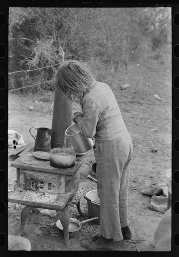 Child of white migrant adding water to boiling beans on stove which was set up immediately after reaching camping grounds near Harlingen, Texas