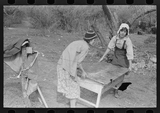 Wife and daughter of migrant moving furniture into camp near Harlingen, Texas