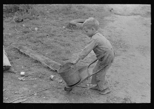 Untitled photo, possibly related to: Child of white migrant worker playing with automobile tools near Harlingen, Texas