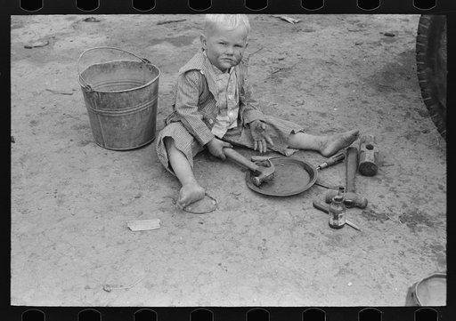 Untitled photo, possibly related to: Child of white migrant worker playing with automobile tools near Harlingen, Texas