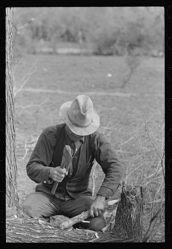 Migrant worker making stakes for the setting up of his tent, vicinity of Harlingen, Texas
