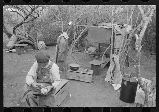 Untitled photo, possibly related to: White migrant worker living in camp with two other migrant men. His sleeping quarters and all worldly possession are to be seen in background. Harlingen, Texas