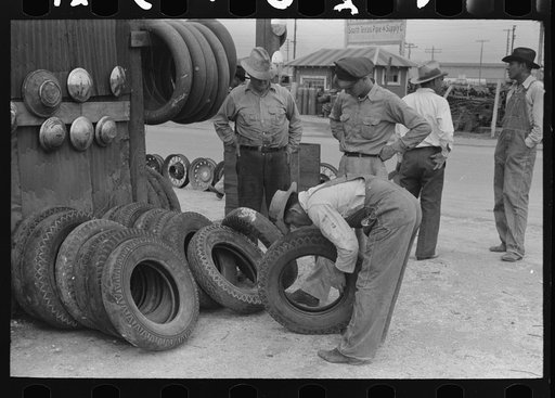Group of men inspecting secondhand tires for sale, Corpus Christi, Texas
