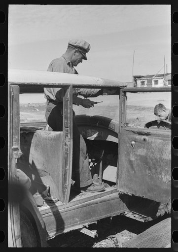 Migrant auto wrecker at work dismantling car, Corpus Christi, Texas