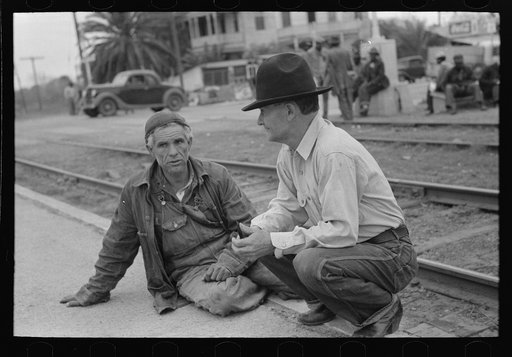 Men squatting on railroad platform, Raymondville, Texas