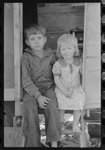 Children of migrants sitting in doorway of trailer, Edinburg, Texas