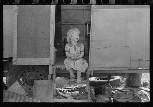 Migrant child sitting in doorway of trailer, Edinburg, Texas