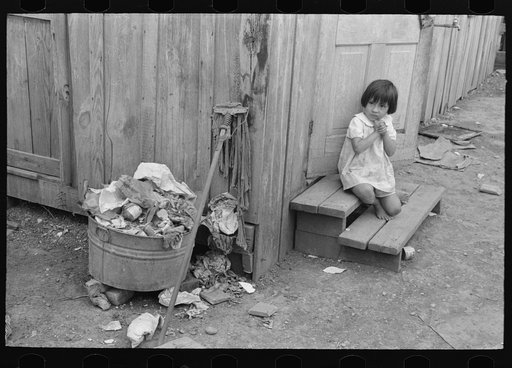 Overflowing garbage can and other things around back door of Mexican house, San Antonio, Texas. Garbage is collected but once a week in the Mexican district