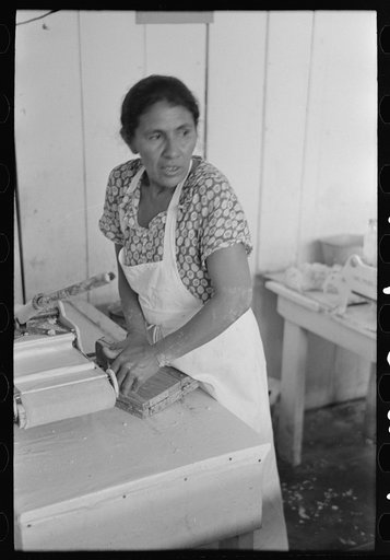 Untitled photo, possibly related to: Mexican woman flattening and shaping tortillas between two boards hinged together, San Antonio, Texas