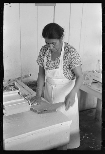 Untitled photo, possibly related to: Mexican woman flattening and shaping tortillas between two boards hinged together, San Antonio, Texas
