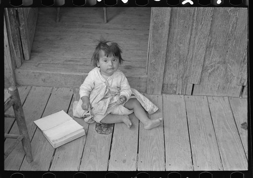Mexican child on porch of house facing corral, San Antonio, Texas