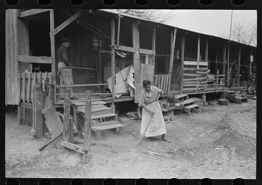 Corral, woman sweeping up trash, San Antonio, Texas