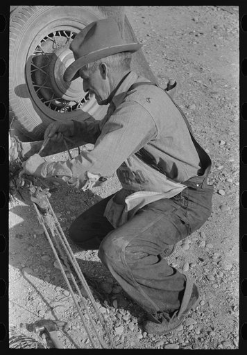 Untitled photo, possibly related to: Mr. Milton, farmer at El Indio, stretching barbed wire by means of block and tackle attached to automobile