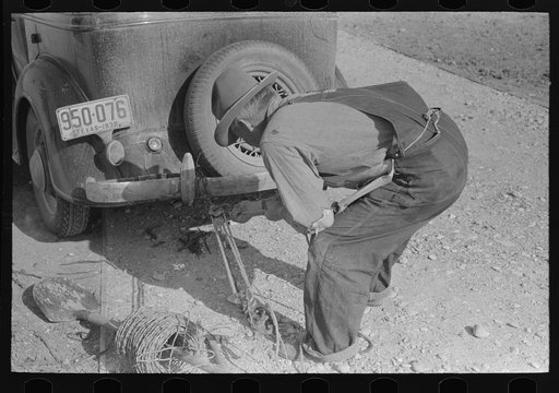 Mr. Milton, farmer at El Indio, stretching barbed wire by means of block and tackle attached to automobile
