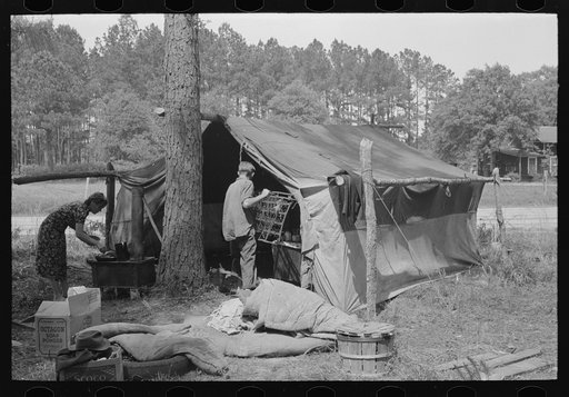 Migratory strawberry pickers camp on outskirts of Hammond, Louisiana. Boy carrying springs had just obtained them at city dump. These springs are used for beds