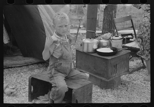 Child of migrant strawberry picker in front of tent home near Hammond, Louisiana