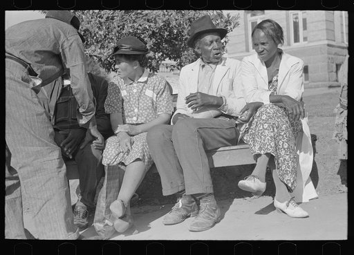 Group of Negroes on bench in square, Marshall, Texas