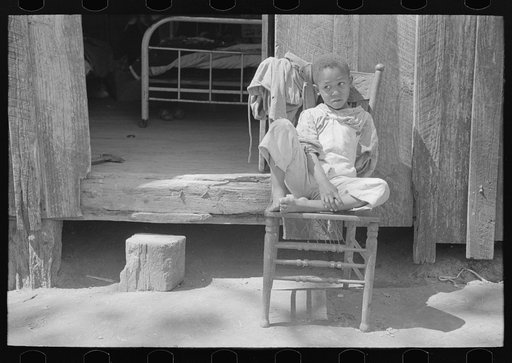 Son of Negro farmer in front of cabin south of Marshall, Texas