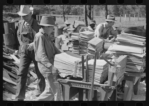 Untitled photo, possibly related to: Young boy packing shingles at small mill near Jefferson, Texas