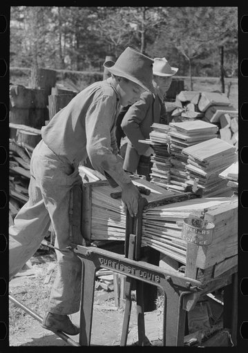 Young boy packing shingles at small mill near Jefferson, Texas