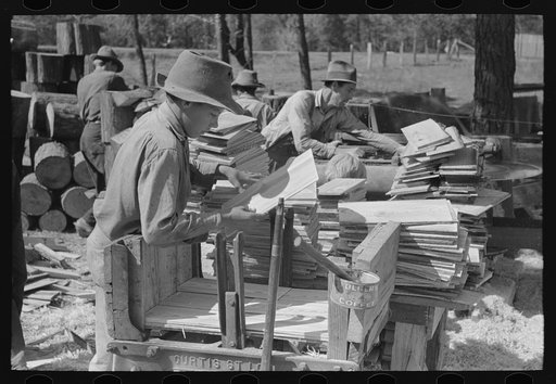 Untitled photo, possibly related to: Young boy packing shingles at small mill near Jefferson, Texas