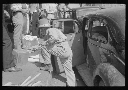 Untitled photo, possibly related to: Grocery clerk putting broom and other supplies in back of automobile, Saturday afternoon, San Augustine, Texas