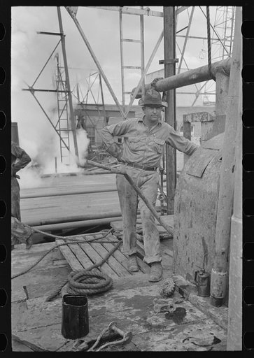 Oil field worker at derrick, Kilgore, Texas