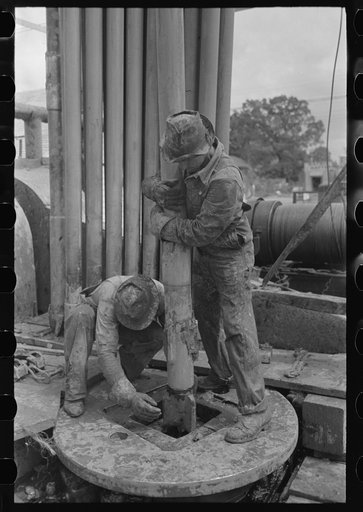 Untitled photo, possibly related to: Guiding bit through rotary table, oil well, Kilgore, Texas